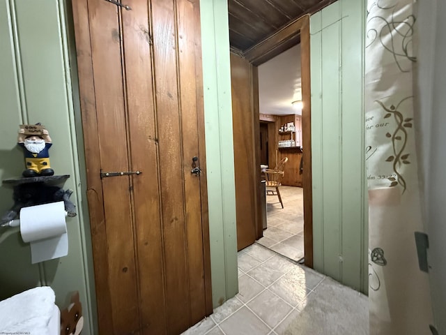 bathroom with wood ceiling, tile patterned flooring, and wood walls