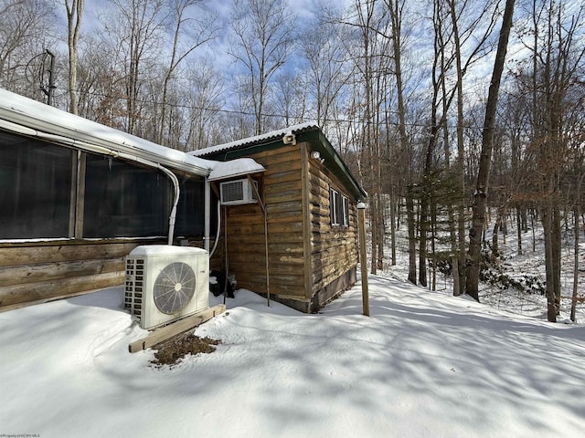 snow covered property with ac unit and a wall unit AC