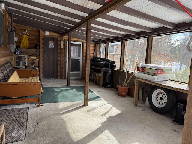 sunroom featuring lofted ceiling with beams and plenty of natural light