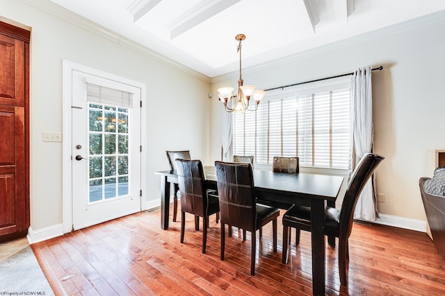 dining room featuring hardwood / wood-style floors, an inviting chandelier, and crown molding