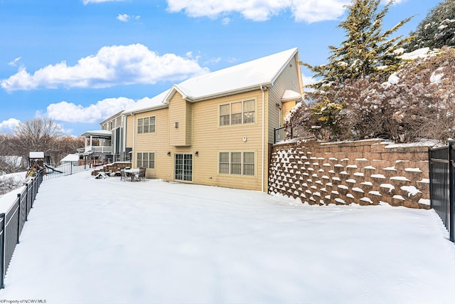 view of snow covered back of property