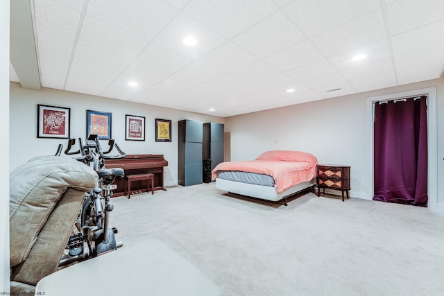 carpeted bedroom featuring a drop ceiling