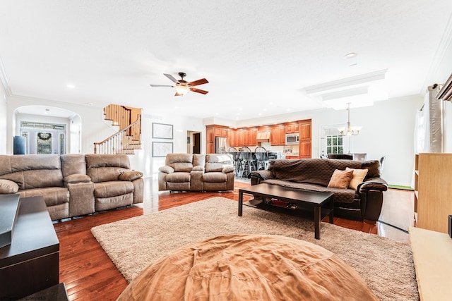 living room with dark hardwood / wood-style flooring, a textured ceiling, and ceiling fan with notable chandelier