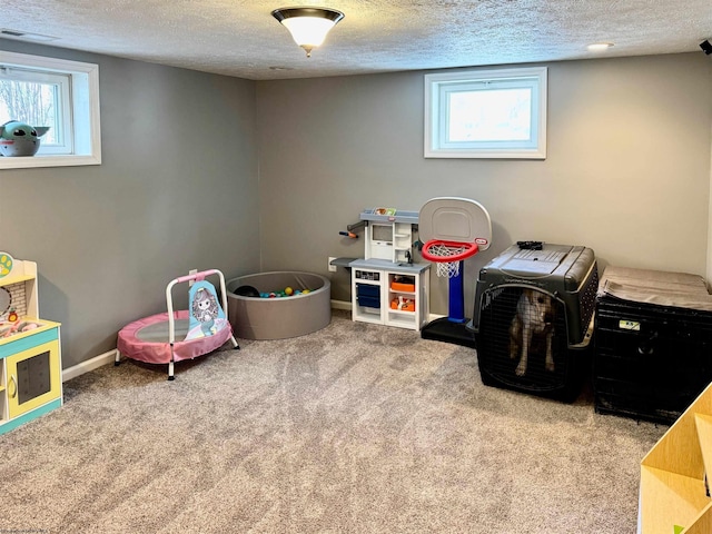 recreation room featuring carpet flooring and a textured ceiling