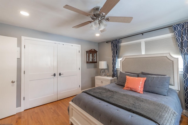 bedroom featuring ceiling fan, light hardwood / wood-style floors, and a closet