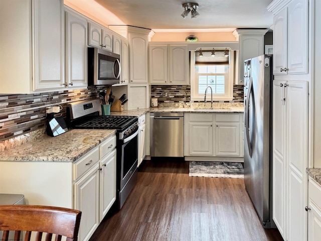 kitchen featuring white cabinetry, sink, light stone countertops, and appliances with stainless steel finishes