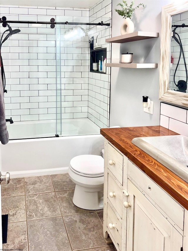 full bathroom featuring vanity, bath / shower combo with glass door, tile patterned floors, and toilet