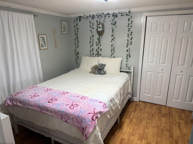 bedroom featuring ornamental molding, light hardwood / wood-style floors, and a closet