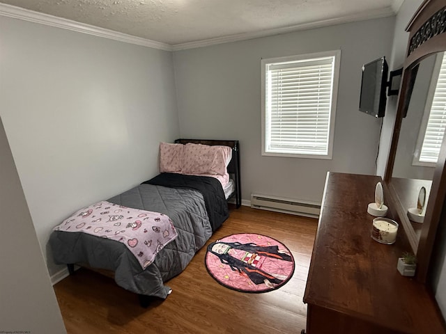 bedroom featuring multiple windows, light wood-type flooring, a textured ceiling, and baseboard heating