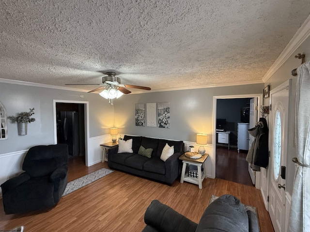 living room featuring ornamental molding, wood-type flooring, and a textured ceiling