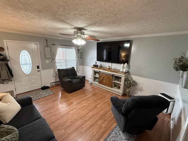 living room featuring crown molding, hardwood / wood-style floors, a textured ceiling, and baseboard heating