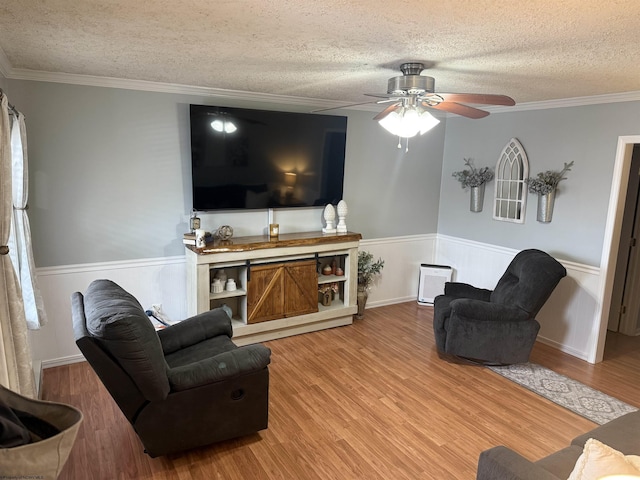 living room featuring crown molding, hardwood / wood-style floors, and a textured ceiling