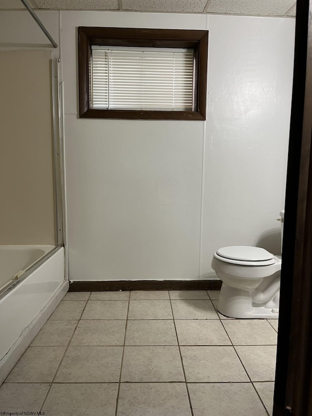 bathroom featuring enclosed tub / shower combo, tile patterned floors, and toilet