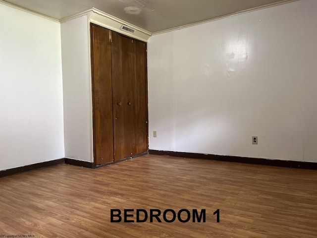 spare room with ornamental molding and hardwood / wood-style floors