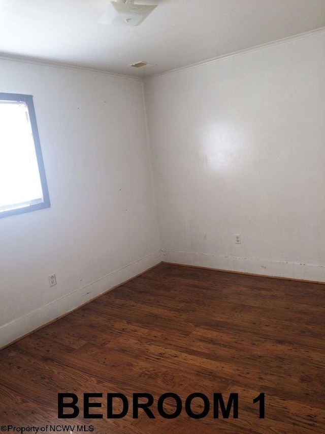 unfurnished room featuring ornamental molding and dark hardwood / wood-style floors