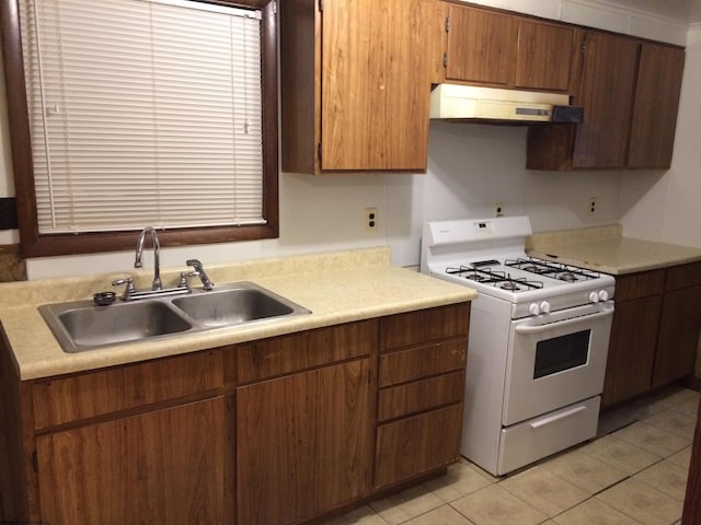 kitchen featuring light tile patterned flooring, sink, and white gas range oven