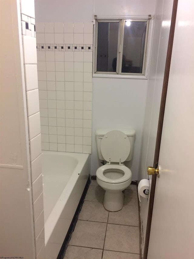 bathroom featuring tile patterned flooring, tile walls, toilet, and a bathing tub