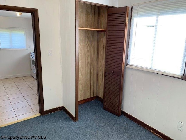 unfurnished bedroom featuring light carpet and a closet