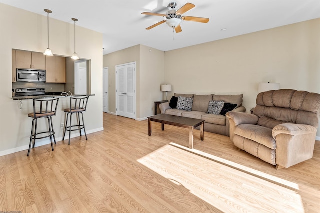 living room featuring ceiling fan and light wood-type flooring