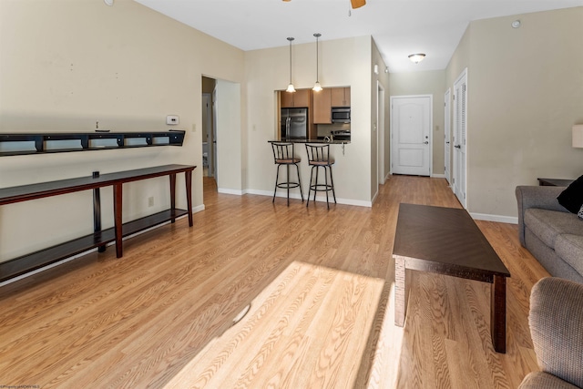 living room with ceiling fan and light hardwood / wood-style floors