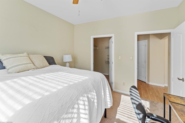 bedroom with a walk in closet, a closet, and ceiling fan