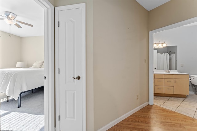 tiled bedroom featuring sink, connected bathroom, and ceiling fan