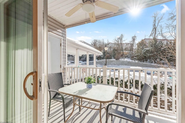 snow covered back of property featuring ceiling fan