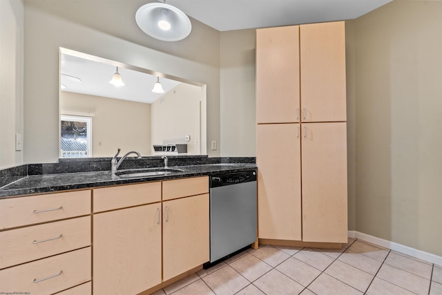 kitchen with pendant lighting, sink, dark stone countertops, stainless steel dishwasher, and light brown cabinets