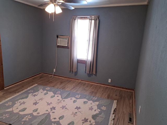 unfurnished room featuring visible vents, baseboards, wood finished floors, and a wall mounted AC