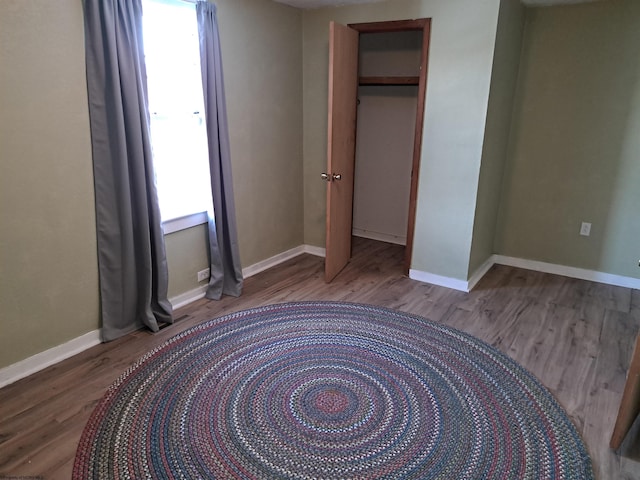 bedroom with a closet, baseboards, and wood finished floors