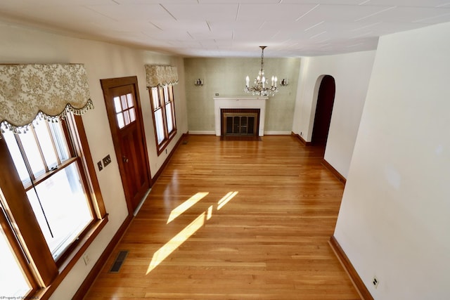 hall with a notable chandelier and light wood-type flooring