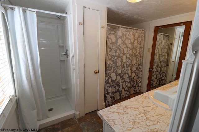 bathroom featuring vanity, a textured ceiling, and walk in shower