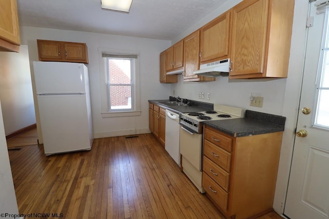 kitchen with white appliances, sink, and light hardwood / wood-style flooring