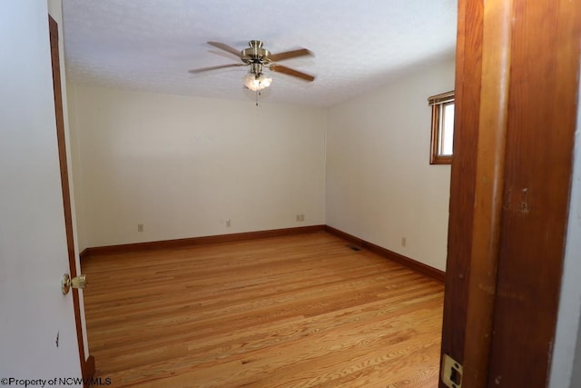 spare room featuring a textured ceiling, light hardwood / wood-style flooring, and ceiling fan