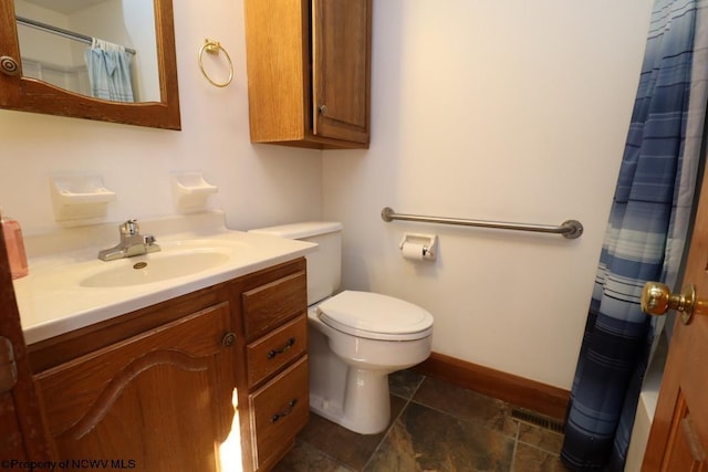 bathroom featuring vanity, curtained shower, and toilet