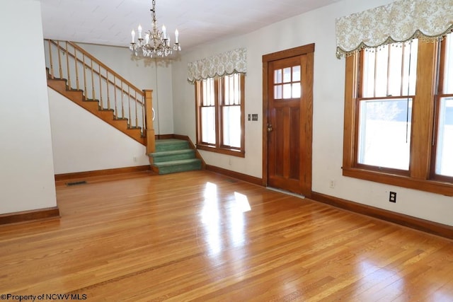 foyer entrance with a chandelier and light hardwood / wood-style flooring