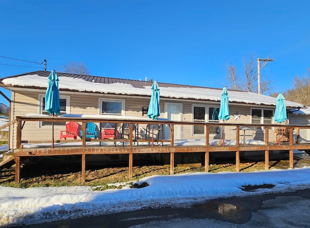 snow covered property featuring a wooden deck