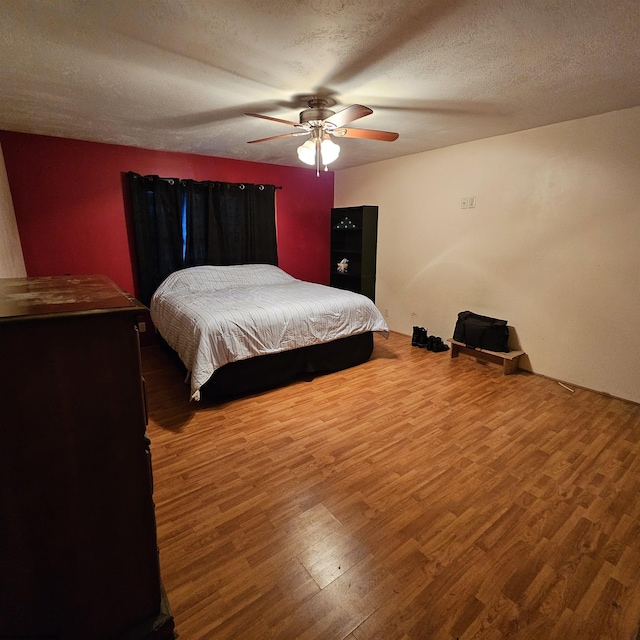 bedroom featuring a textured ceiling, wood-type flooring, and ceiling fan