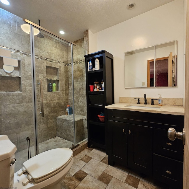 bathroom with vanity, toilet, and a shower with shower door