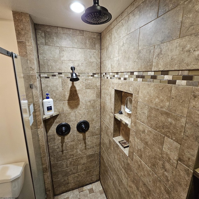 bathroom featuring toilet and tiled shower