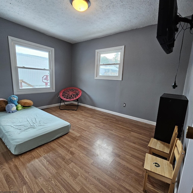 bedroom with hardwood / wood-style flooring and a textured ceiling