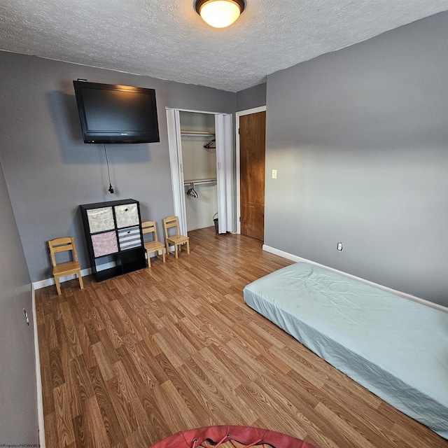 bedroom with hardwood / wood-style flooring, a closet, and a textured ceiling