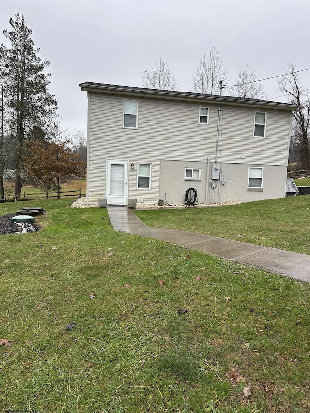 rear view of property featuring a lawn