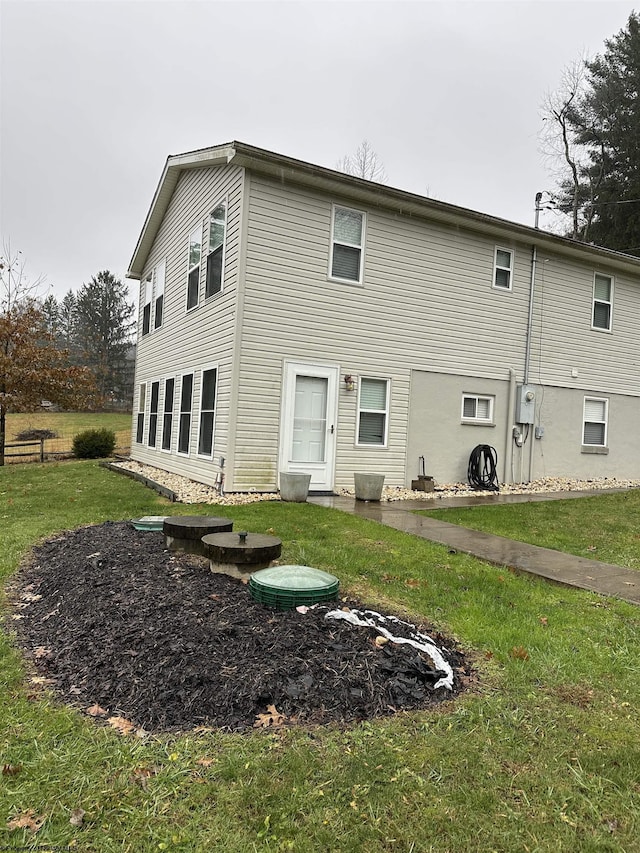 rear view of property featuring a lawn