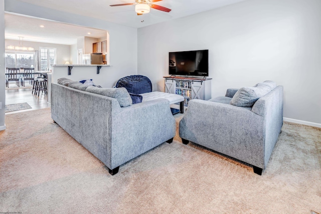 living room featuring light colored carpet and ceiling fan