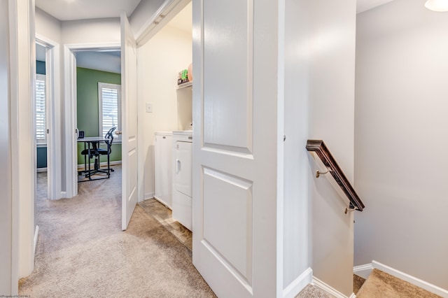 hallway featuring light carpet and independent washer and dryer