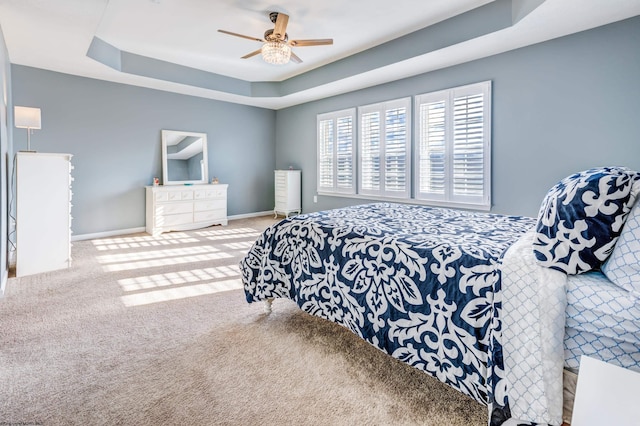 bedroom featuring ceiling fan, a raised ceiling, and carpet floors