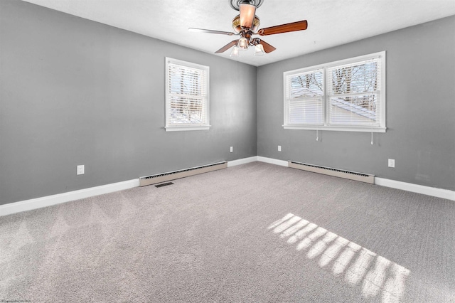 carpeted empty room with a wealth of natural light, a baseboard radiator, and ceiling fan