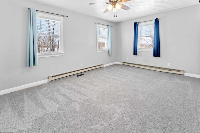 carpeted spare room featuring ceiling fan, a healthy amount of sunlight, and baseboard heating