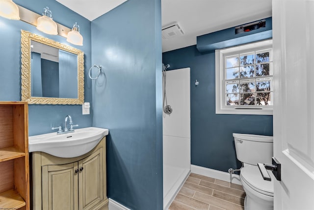 bathroom featuring vanity, wood-type flooring, and toilet